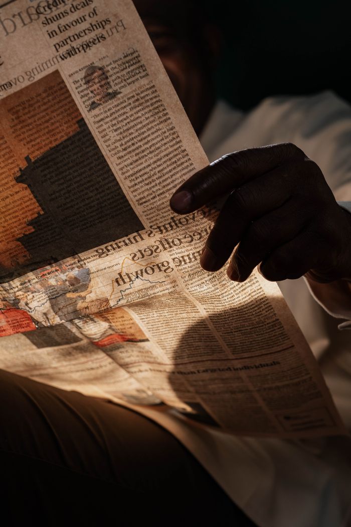 Captivating image of a person reading a newspaper, creating a dramatic shadow effect.